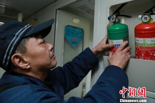 梁建军对车上消防设施进行检查。　钟欣 摄