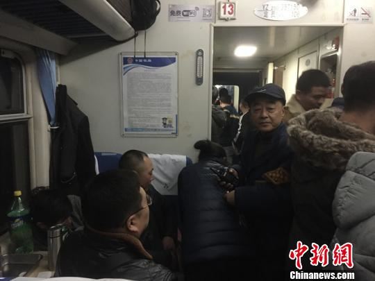 梁建军在拥挤的车厢中巡视。　钟欣 摄